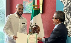 Momento en el que Matheus Doria recibe el certificado oficial de naturalización como ciudadano mexicano
