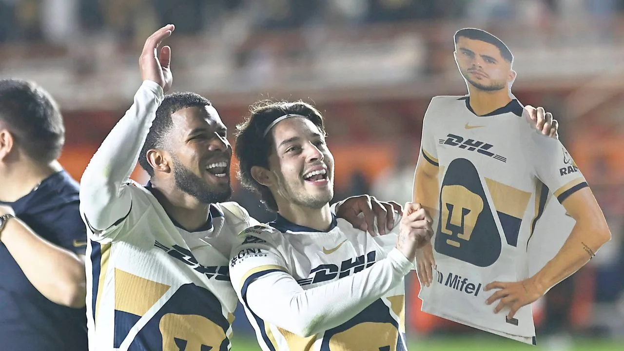 Pedro Vite y Jordan Carrillo celebran junto a un afiche de Alan Medina, el triunfo ante Pachuca.