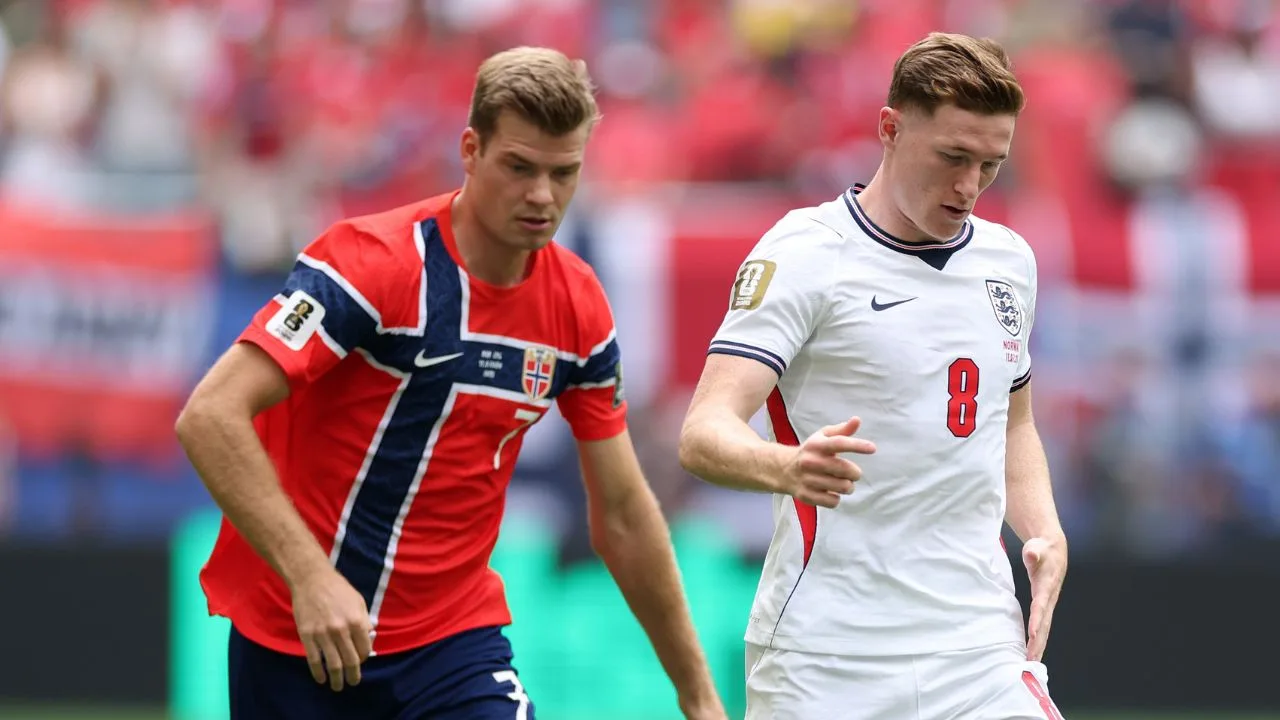 Alexander Sorloth de Noruega y Elliot Anderson de Inglaterra disputan un balón en el campo. 